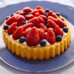 Scrumptious homemade fruit tart topped with fresh strawberries and blueberries.