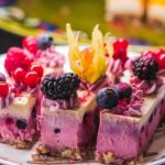 Tantalizing slices of mixed berry cheesecake topped with fresh blackberries, red currants, and blueberries.